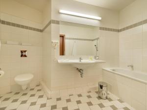 a bathroom with a sink and a tub and a toilet at EA Hotel Populus in Prague