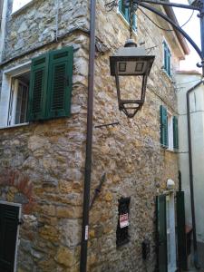 una luz de la calle junto a un edificio de piedra con persianas verdes en Casa Ida, en Monte Marcello