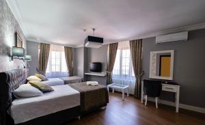 a hotel room with two beds and a television at Levent Hotel Istanbul in Istanbul
