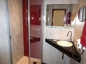 a bathroom with a glass shower and a sink at Gästehaus Rössle in Weinstadt