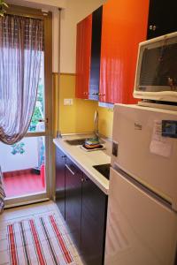 a kitchen with a refrigerator and a microwave at La Casetta del Viaggiatore - "Traveller's Home" in Torre del Lago Puccini