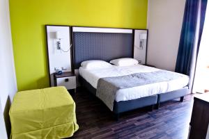 a bedroom with a bed and a green wall at Hotel Gasparina in Castelnuovo del Garda