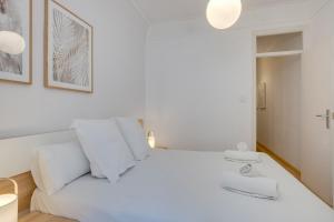 a hotel room with a white bed and white walls at Feelathome Center Apartments in Barcelona