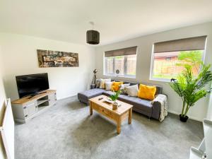 a living room with a couch and a tv at Contractor House - Free Parking - Garden - CMK in Milton Keynes