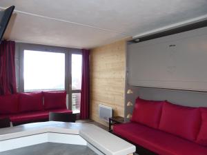 a living room with red couches and a large window at travelski home select - Vue Mont Blanc in Aime-La Plagne