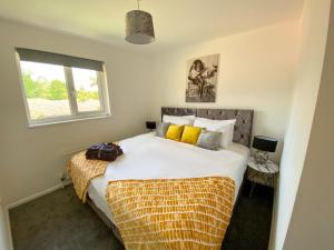 a bedroom with a large white bed with yellow pillows at Contractor House - Free Parking - Garden - CMK in Milton Keynes