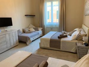a hotel room with two beds and a couch at Your House Rooms in Genova