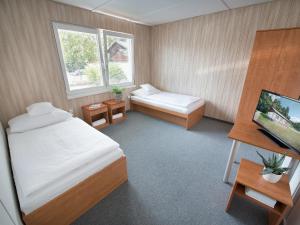 Dormitorio con cama, escritorio y TV en EA Rodinné chatky Kraskov en Kraskov