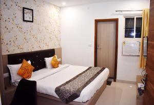een slaapkamer met een groot bed met oranje kussens bij HOTEL UMA PALACE in Gorakhpur +19 foto's