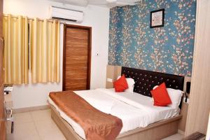 Un dormitorio con una cama con almohadas rojas. en HOTEL UMA PALACE, en Gorakhpur 19 fotos más