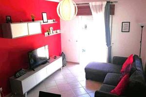 un soggiorno rosso con divano e TV di Falesia - near the beach - The GAVEL Apartment ad Albufeira
