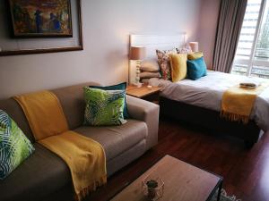 a living room with a couch and a bed at 45 Lighthouse Mall Apartment in Durban