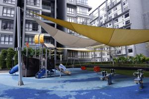 a playground in front of a building with swings at NORDIC Geniehome2BR1studio Free 90mbps WIFI and Carpark at Utropolis Suite Shah Alam in Shah Alam