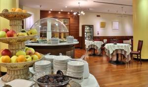 クアルト・ダルティーノにあるクラウン プラザ ホテル ヴェニス イーストのレストランのテーブル(皿、果物付)