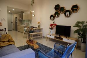 a living room with a couch and a tv at NORDIC Geniehome2BR1studio Free 90mbps WIFI and Carpark at Utropolis Suite Shah Alam in Shah Alam