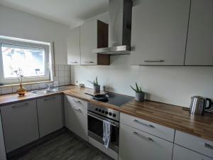 a kitchen with white cabinets and a stove top oven at ideale Messe/Airport Wohnung 15min Fahrtweg in Kirchheim unter Teck