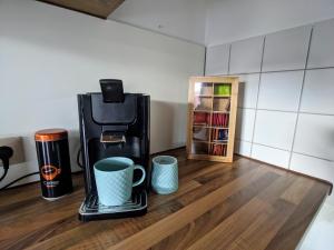 a coffee maker and two cups on a counter at ideale Messe/Airport Wohnung 15min Fahrtweg in Kirchheim unter Teck