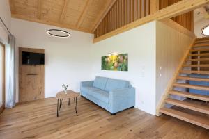 a living room with a blue chair and a table at Niederauer Hof in Neubeuern