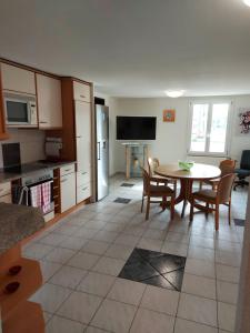 una cucina e un soggiorno con tavolo, cucina e tavolo con sedie di Appartamenti Jurahof a Däniken