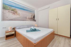 ein Schlafzimmer mit einem Bett und einem blauen Handtuch darauf in der Unterkunft Apartmani Joško Duće - Omiš in Duće
