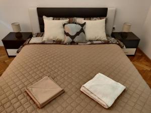 a large bed with two pillows on top of it at White Apartment in Kazanlŭk