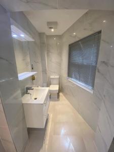 a white bathroom with a sink and a toilet at Best Western Victoria Palace in London