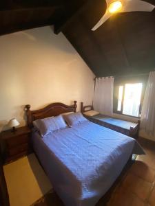 a bedroom with a blue bed and a window at Pousada Morada Da Prainha in Torres