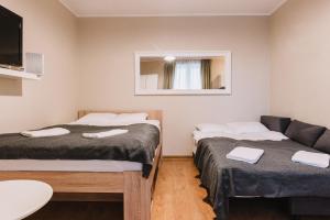 ein kleines Zimmer mit 2 Betten und einem Sofa in der Unterkunft Sopot Host Stacja in Sopot