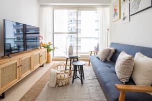 a living room with a blue couch and a tv at Frank Porter - Mayfair Tower in Dubai