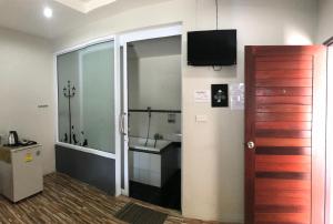a bathroom with a shower and a television on the wall at Janrawee Resort in Ban Phang Kan Nua