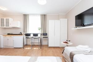 a white room with two beds and a kitchen at Sopot Host Stacja in Sopot