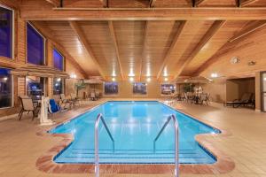 een groot zwembad in een kamer met tafels en stoelen bij SureStay Plus Hotel by Best Western Litchfield in Litchfield