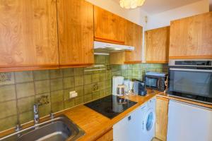 een keuken met houten kasten, een wastafel en een magnetron bij RESIDENCE DU CAP AP2027 - Villefranche-sur-Mer, by Riviera Holiday Homes in Villefranche-sur-Mer +8 foto's