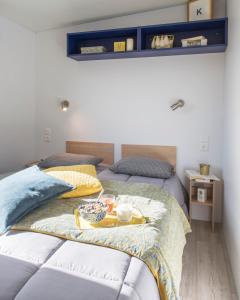 ein Schlafzimmer mit 2 Betten und einem Tablett mit Essen drauf in der Unterkunft Camping Le Walric in Saint-Valery-sur-Somme