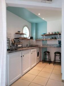 eine Küche mit einer Spüle und einer Waschmaschine in der Unterkunft Appart Sophyann in Saint-Gilles-les-Bains