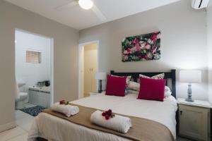 a bedroom with a large bed with red pillows at 9 Bronze Bay in Durban