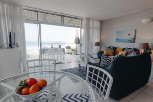 a living room with a glass table with a bowl of fruit at 9 Bronze Bay in Durban