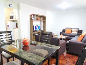 a living room with a table and a couch at Eral Apartments San Isidro in Lima