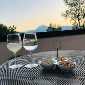 two glasses of wine and a bowl of food on a table at Tuscan Skye - Caterina Studio Apartment in Barga