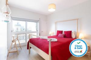 a bedroom with a bed with red sheets and a window at Trendy Bright Flats with Jacuzzi - 5 min Beach in Matosinhos