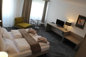 um quarto de hotel com uma cama, uma secretária e uma cadeira em Garni Hotel Schmaus em Viechtach