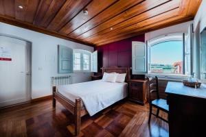 Un dormitorio con una cama y un techo de madera. en Pátio da Figueira, en Torres Vedras 36 fotos más