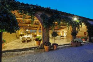 an outdoor patio with a table in a building at villa San Fabiano with heated pool in Monteroni dʼArbia