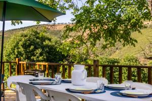 a table with plates and a vase on top at Casa da Corriça - Alojamento Local in Negreda