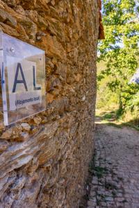 Negreda的住宿－Casa da Corriça - Alojamento Local，石墙边的标志