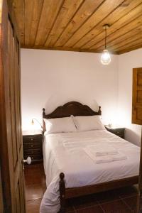 a bedroom with a white bed with a wooden ceiling at Casa da Corriça - Alojamento Local in Negreda