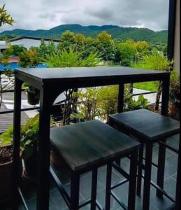 uma mesa e 2 cadeiras numa varanda com vista em Mae-Sa-Riang Home em Mae Sariang