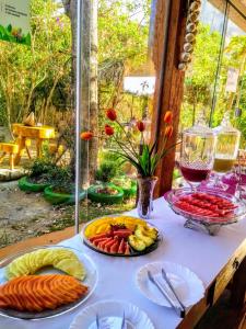 uma mesa com pratos de comida em cima em Pousada Rancho dos Ipês em Alto Paraíso de Goiás