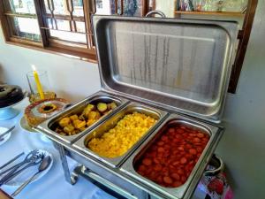 a table with three trays of food on a table at Pousada Rancho dos Ipês in Alto Paraíso de Goiás