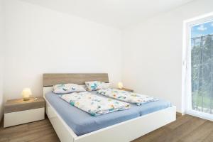 Schlafzimmer mit einem Bett mit blauer Bettwäsche und einem Fenster in der Unterkunft Ferienwohnung Eyrich Eg in Lindau